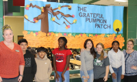 students standing in front of The Grateful Pumpkin Patch banner