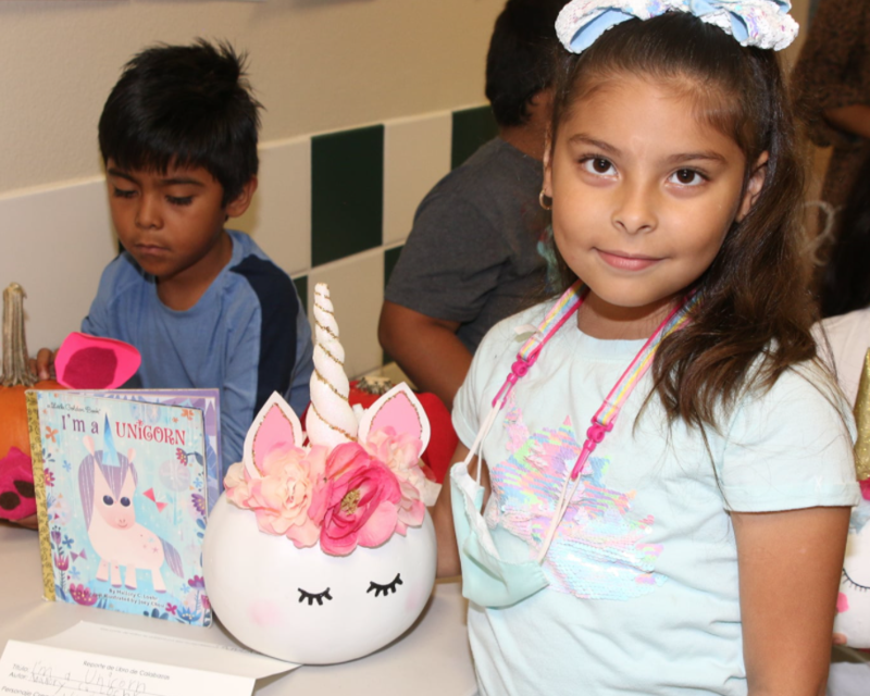 student with decorated unicorn pumpkin